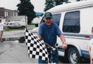 terry clark holding a checkered flag riding a bike